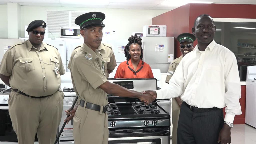 Acting Permanent Secretary in the Ministry of Tourism Mr. John Hanley hands over a new stove to Mr. Desmond Morton, Principal Officer at the Prison Farm on Nevis at the Horsfords Nevis Furniture and Appliances store on July 26, 2017. Looking on are (back left to right) Prison Officers Mc Mully Isaac and Jermaine Hendrickson, Ms. Sylvia Dore, Administrative Assistant in the Ministry of Tourism and Prison officer Sergeant Stanford Browne